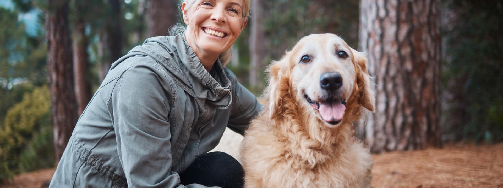 A person petting a dog in the woods, Being Active with Your Pet:  Strengthening Your Bond & Preventing Pet Obesity